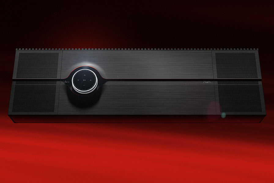 Naim Mu-so Utopia with illuminated dial on a red backdrop